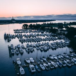 High angle view of white ships on a river surrounded by greenery and towns during sunset